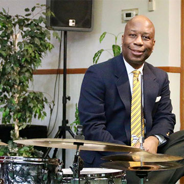 Ron Savage stitting at a drum set
