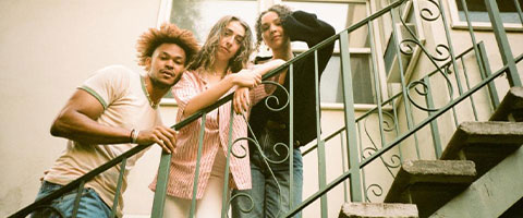 Vocal trio Tiny Habits pose on an outdoor staircase