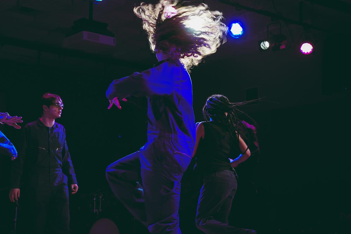 group of students spinning on stage in blue light