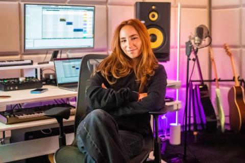 a woman sitting in front of a studio editing console