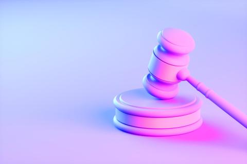 Pink gavel in a pink-blue hued room